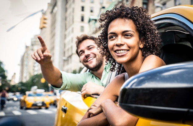 Glückliches Paar auf einem gelben Taxi in New York