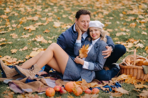 Glückliches Paar, das die goldene Herbstfrühlingssaison im Park genießt