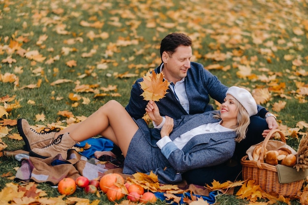 Glückliches Paar, das die goldene Herbstfrühlingssaison im Park genießt