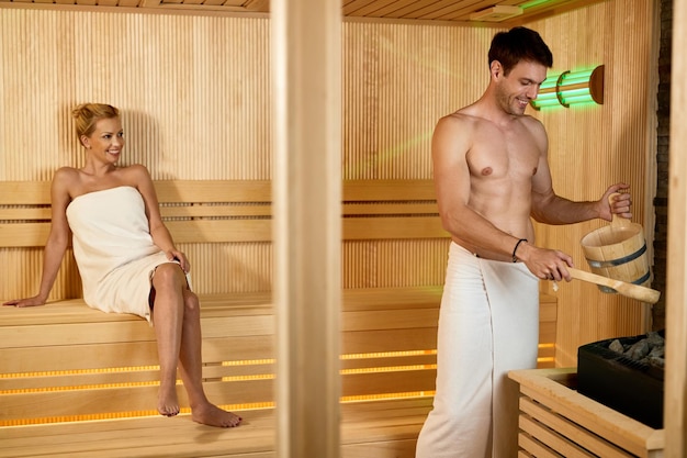 Glückliches Paar, das gemeinsam in der Sauna im Wellnesscenter genießt Der Fokus liegt auf dem Menschen