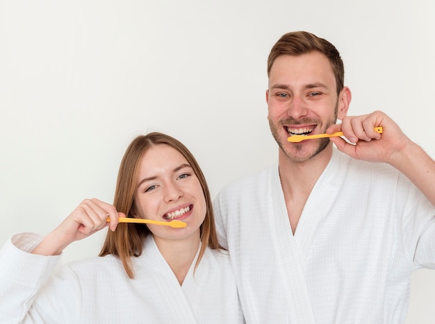 Foto glückliches paar, das ihre zähne putzt