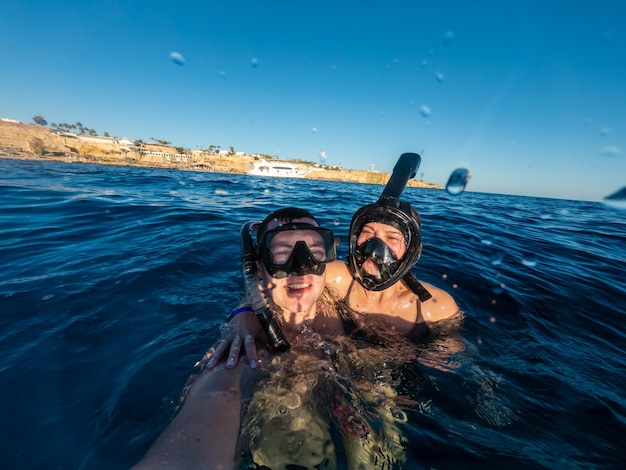 Glückliches Paar, das im Roten Meer schnorchelt und Selfie macht