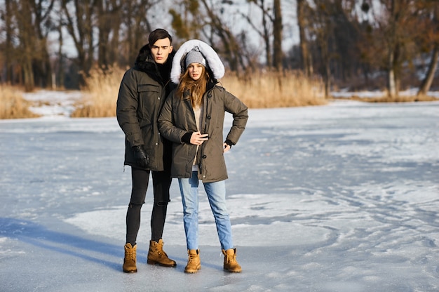 glückliches Paar, das im Winter draußen umarmt und lacht