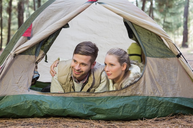 Glückliches Paar, das im Zelt nach einer Wanderung liegt