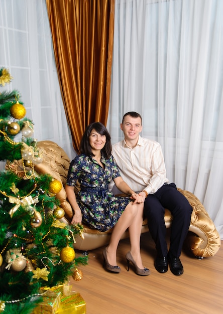 Glückliches Paar, das mit dem Weihnachtsbaum aufwirft