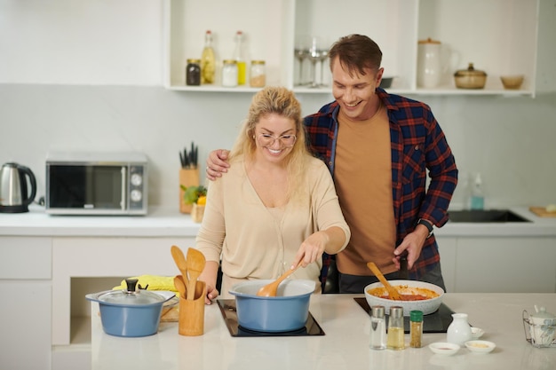 Glückliches Paar, das Nudeln kocht