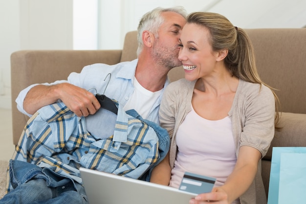 Glückliches Paar, das online auf der Couch kauft