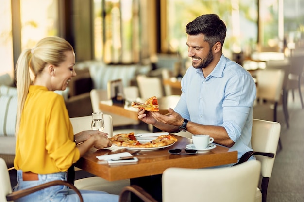 Glückliches Paar, das Pizza in einem Restaurant isst