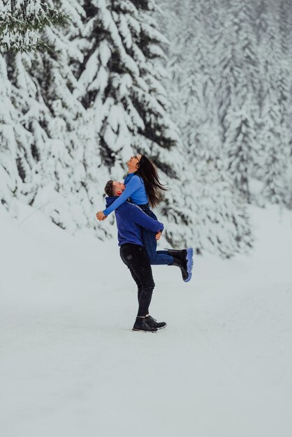 Glückliches Paar, das sich im Winter im Freien umarmt und lacht. Selektiver Fokus. Hochwertiges Foto