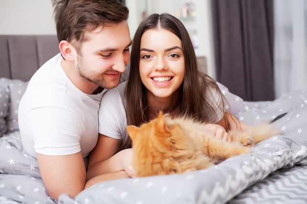 Glückliches Paar, das Spaß im Bett hat. Intimes sinnliches junges Paar im Schlafzimmer, das sich gegenseitig genießt