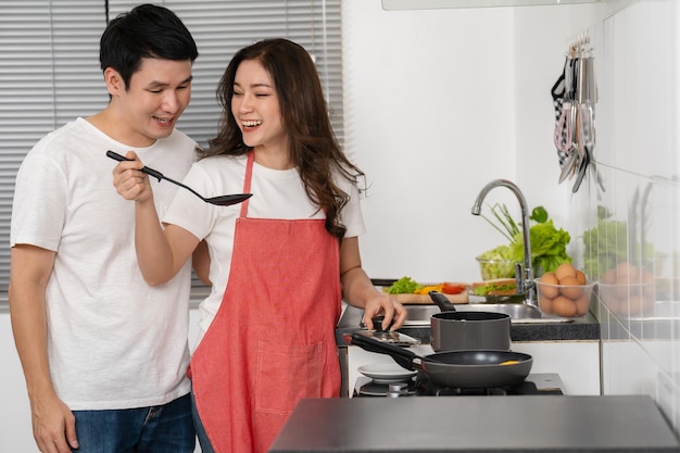 Glückliches Paar, das zu Hause in der Küche kocht und Essen zubereitet