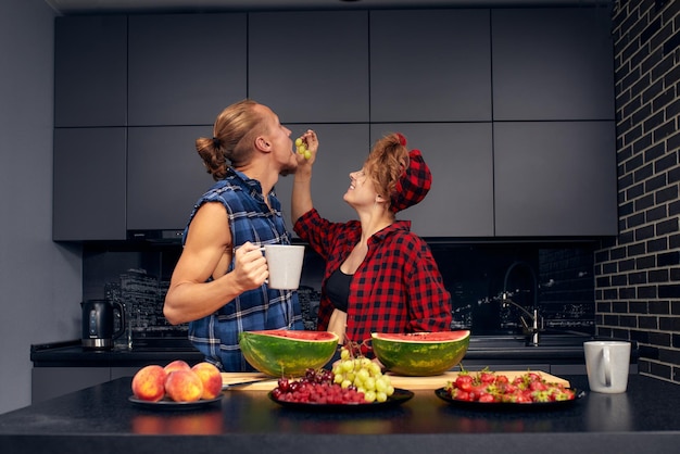 Glückliches Paar, das zu Hause in der Küche steht und beim ersten Dating gemeinsam ein leckeres Abendessen zubereitet