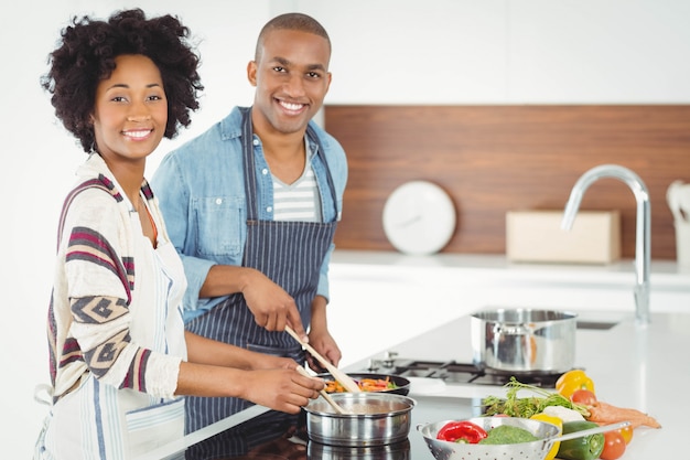 Glückliches Paar, das zusammen Gemüse kocht