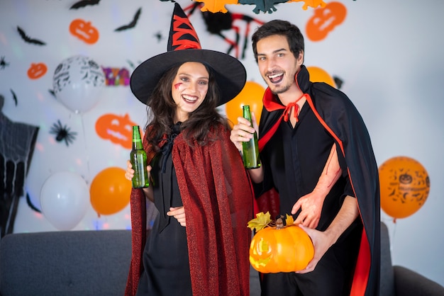 Glückliches Paar der Liebe in Kostümen und Make-up auf einer Feier von Halloween