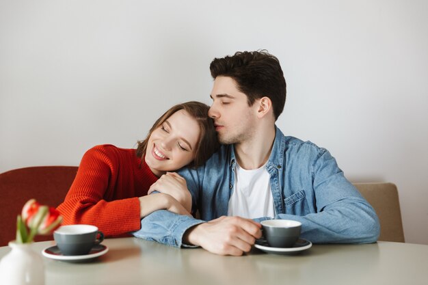 Glückliches Paar Frau und Mann genießen, während im Restaurant ruhen und Kaffee oder Tee zusammen trinken