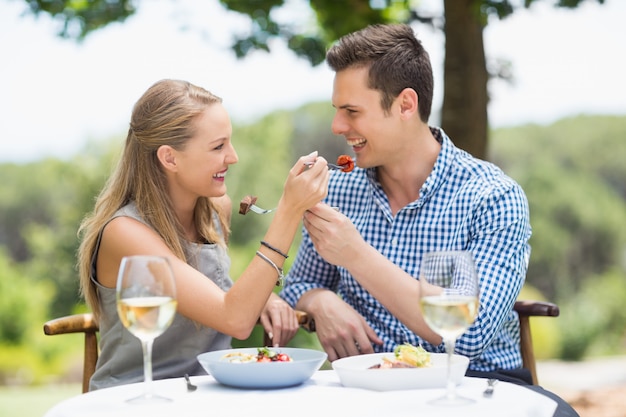 Glückliches Paar füttert sich gegenseitig mit Essen