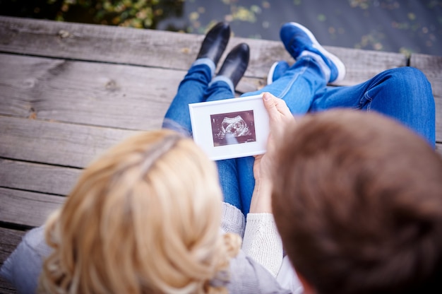 Glückliches Paar halten Ultraschallscan ihres Babys