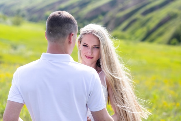 Glückliches Paar im Freien. Lächelnde Paare, die in einem Park sich entspannen. Familie über Natur-Grün-Hintergrund. Lifestyle-Paar, das im Wald spazieren geht