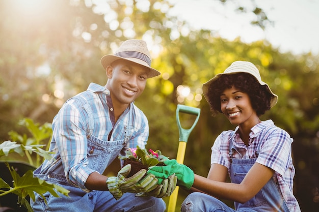 Glückliches Paar im Garten, der Blumen hält