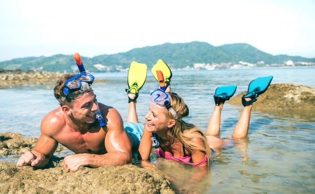 Glückliches Paar in der Liebe, die Spaß am tropischen Strand in Thailand mit Schnorchelmaske und -flossen hat