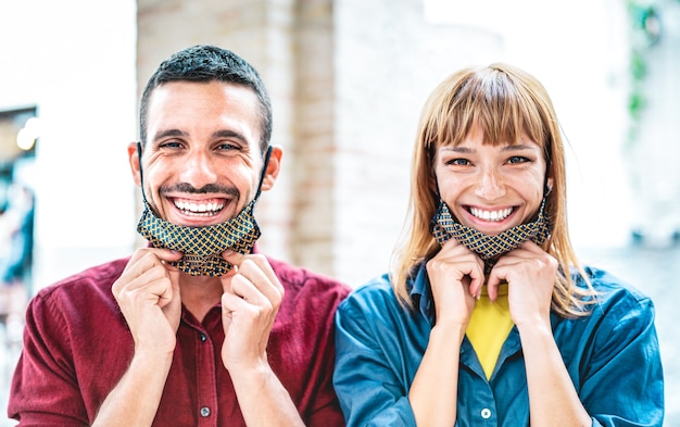 Glückliches Paar in der Liebe lächelnd mit offener Gesichtsmaske