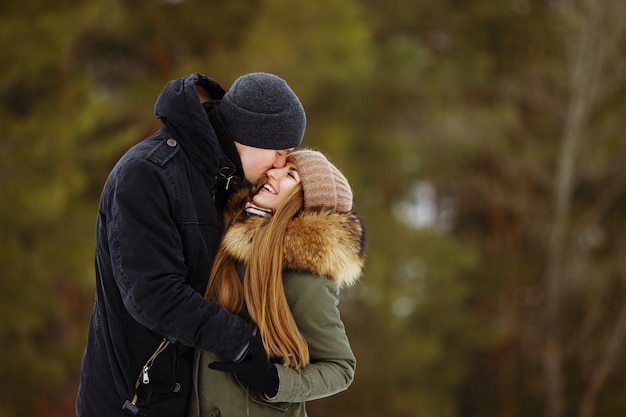 Glückliches Paar in der Umarmung im verschneiten Winter kalten Wald, Liebe und Beziehungen