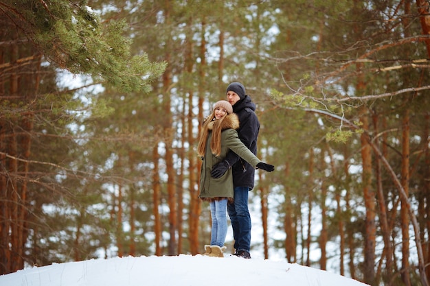 Glückliches Paar in der Umarmung im verschneiten Winter kalten Wald, Liebe und Beziehungen