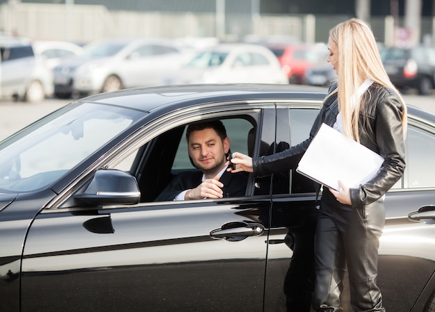 Glückliches Paar kaufen neues modernes schwarzes Auto