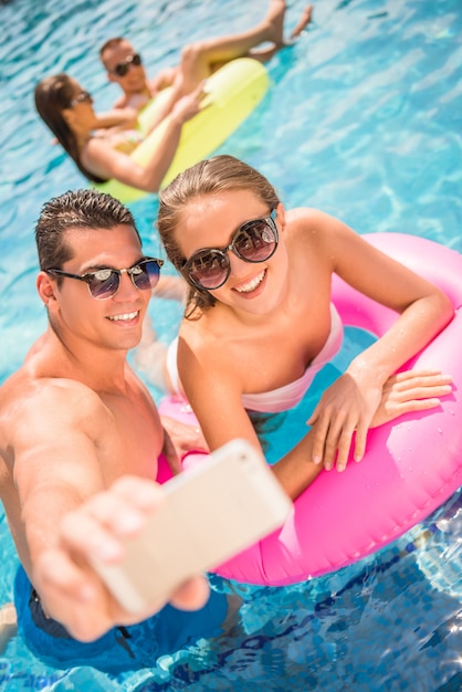 Glückliches Paar machen selfie beim Haben des Spaßes im Pool.