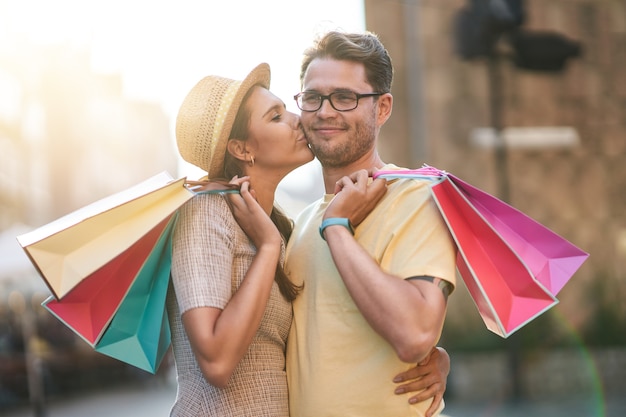 glückliches Paar mit Einkaufstüten in der Stadt