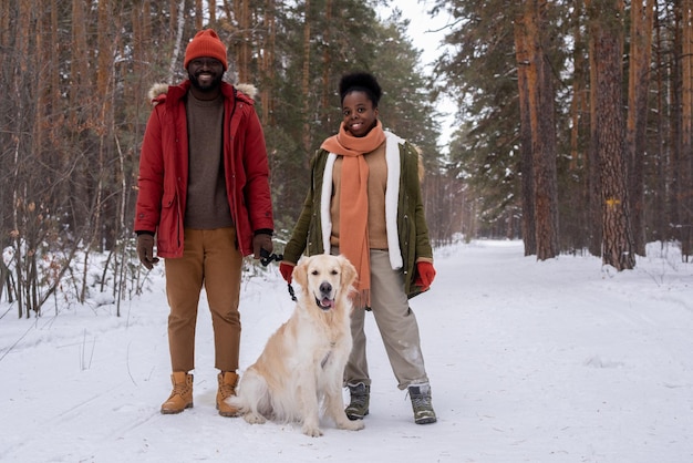 Glückliches Paar mit Hund im Wald