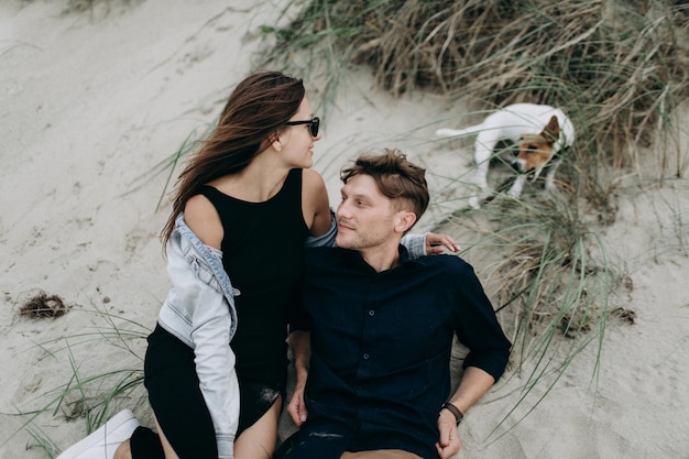 Glückliches Paar mit ihrem Hund am Strand