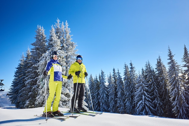 Glückliches Paar Skifahrer posieren auf Skiern vor dem Skifahren im Skigebiet