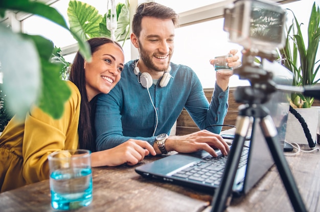 Glückliches Paar von Bloggern, die ein Video aufnehmen, das sich auf das Posten in sozialen Netzwerken vorbereitet