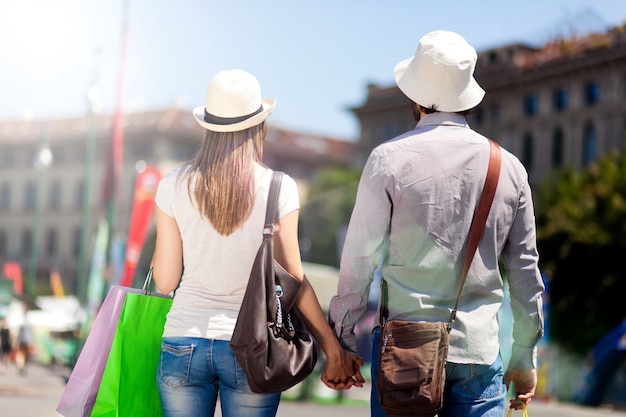 Foto glückliches paar von touristen, die in der stadt kaufen