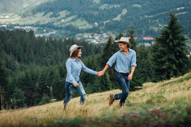 Glückliches Paar von Wanderern, die Händchenhalten freudig wandern