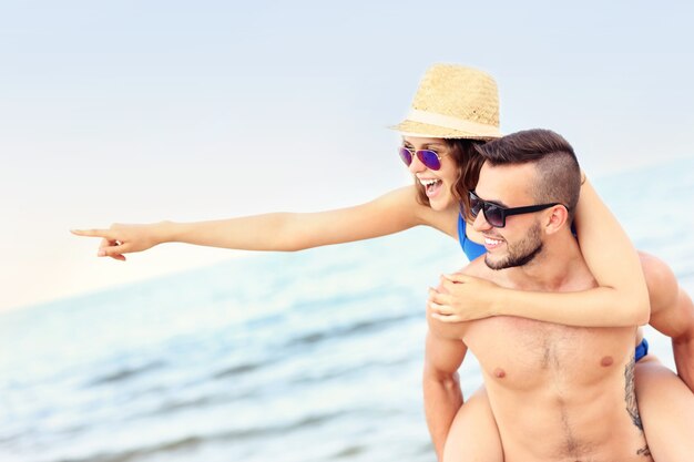 glückliches Paar zeigt auf etwas am Strand