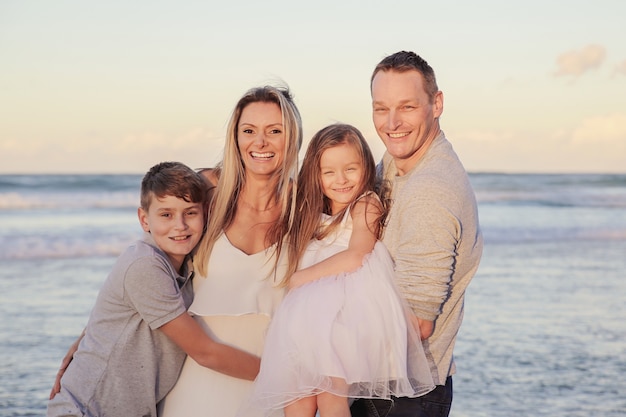 Glückliches Porträt der vierköpfigen Familie auf dem Strand