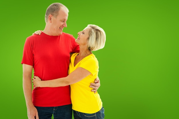 Glückliches reifes Paar, das gegen grüne Vignette umarmt und lächelt