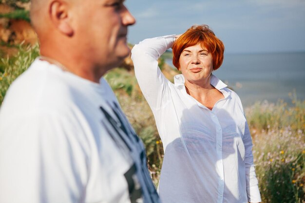 Glückliches reifes Paar posiert an einem sonnigen Tag am Strand