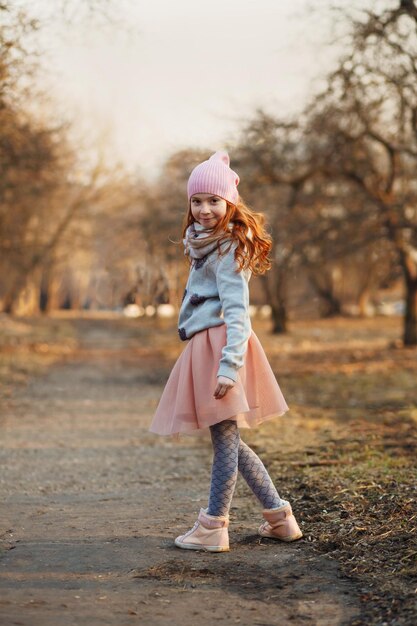 Glückliches rothaariges Mädchen mit Sommersprossen in einem sonnigen Park Frühling oder Herbst Glückliche unbeschwerte Kindheit