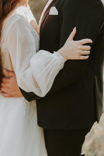 Glückliches schönes Hochzeitspaar, Braut und Bräutigam am Hochzeitstag im Freien auf dem Bergfelsen.