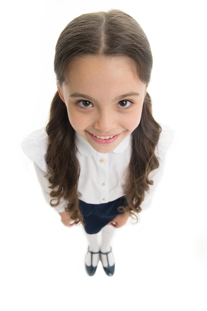 Glückliches Schulmädchen mit dem langen Haar getrennt auf Weiß. Lächeln des kleinen Mädchens in der Schuluniform, Draufsicht.