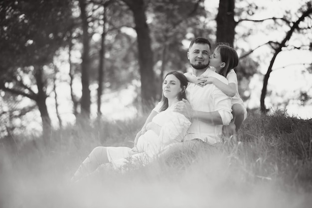 Foto glückliches schwangeres paar mit tochter in der sommernatur