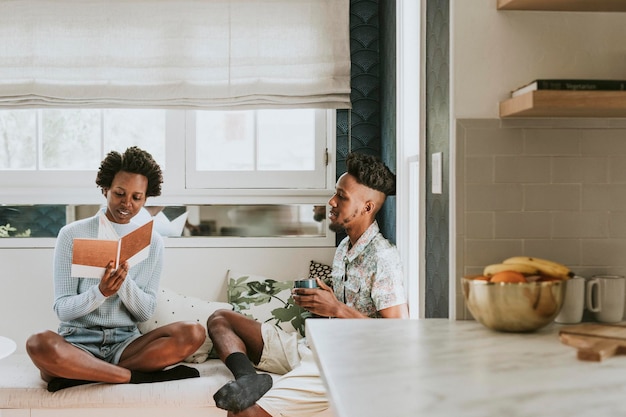 Glückliches schwarzes Paar, das zu Hause ein Buch liest