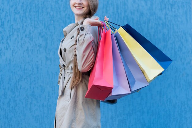 Glückliches shopaholic der jungen Frau mit bunten Taschen