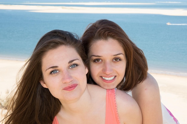 Glückliches Sommerferien-Sommerfrauenporträt am Strand, der Spaß hat