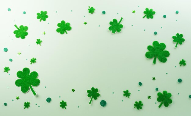 Glückliches St. Patrick's Day-Dekorationskonzept aus Kleeblättern auf grünem Pastellhintergrund