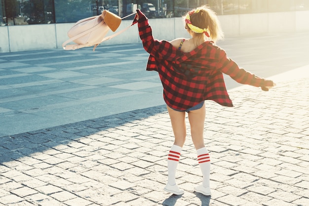 Foto glückliches stilvolles mädchen mit rucksack