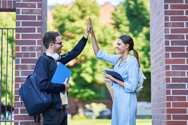 glückliches Studentenpaar auf dem Campus, das im Freien studiert